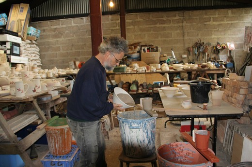 Robb glazing a large mixing bowl.