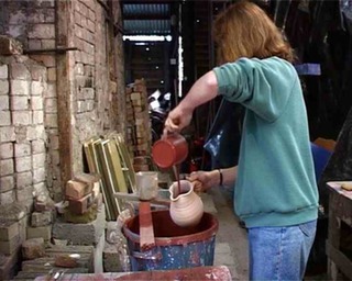  Meredith glazing a large jug at an Irish pottery in County Cork Ireland